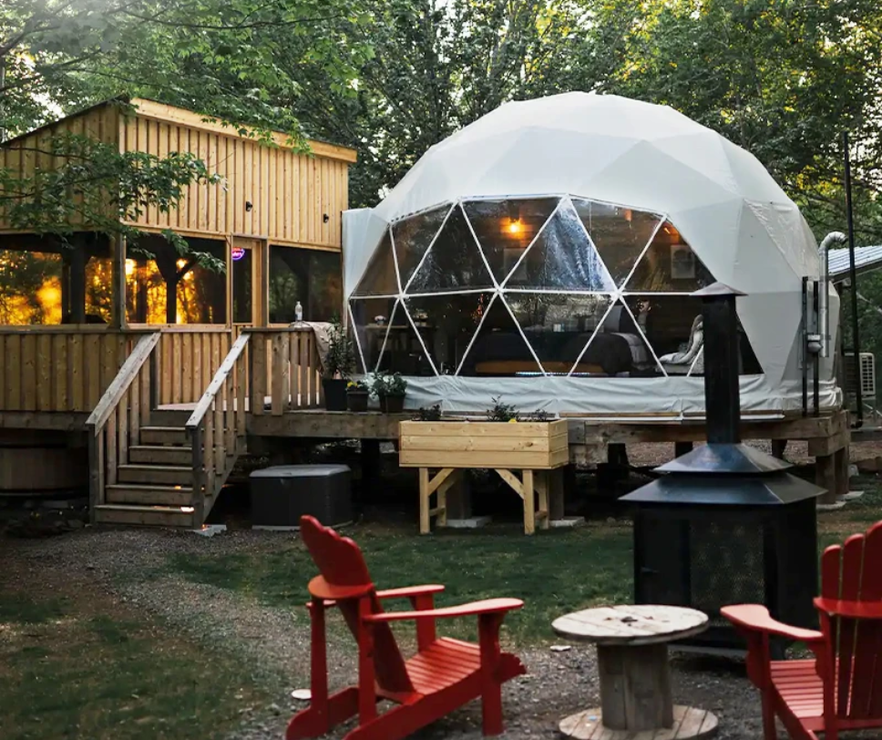 Geodesic dome with cabin compound in forest setting